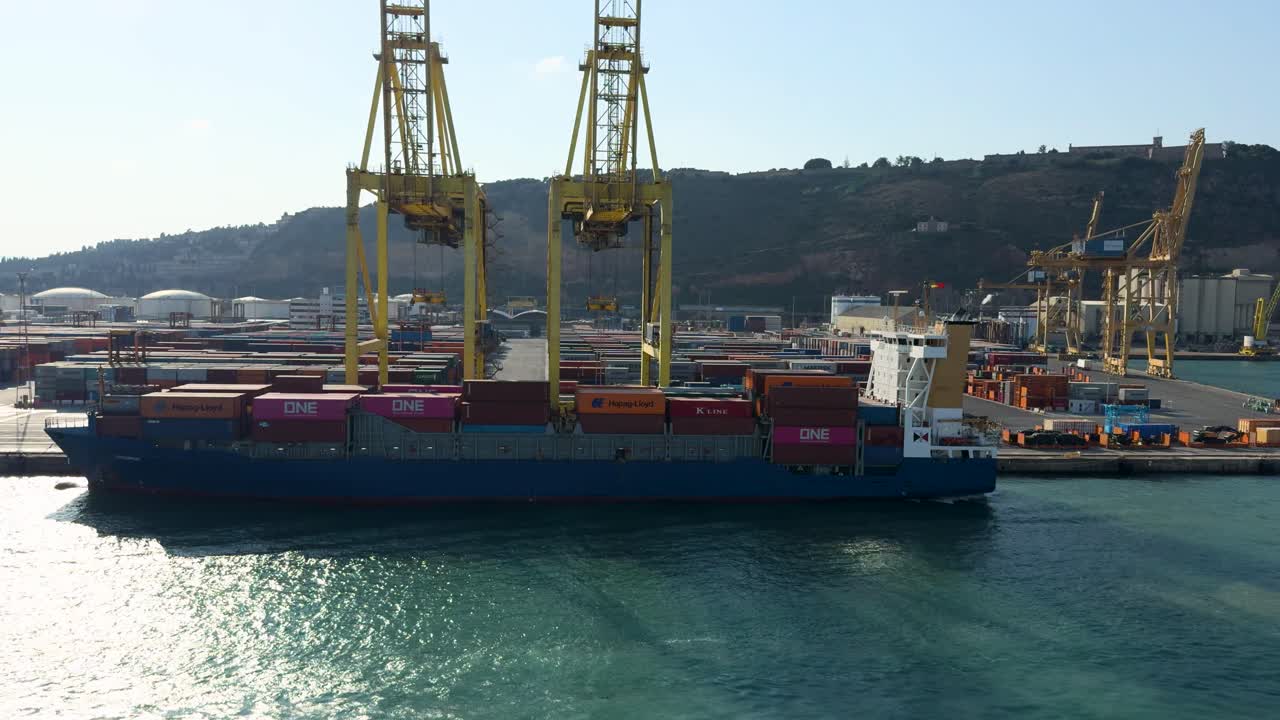 Port of Barcelona, container ship moored in front of the giant crane