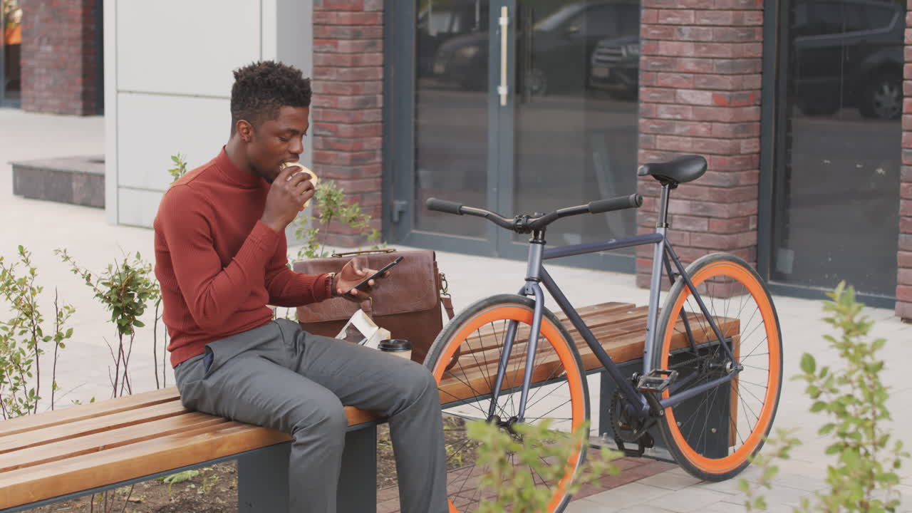 African American Man Eating Sandwich Outdoors