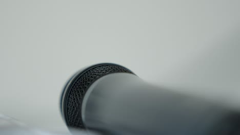 slow zoom in on a microphone laying on its side, blurred background, shallow depth of field