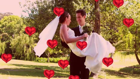 Animation-of-multiple-red-heart-balloons-floating-over-newly-married-couple-groom-carrying-his-bride