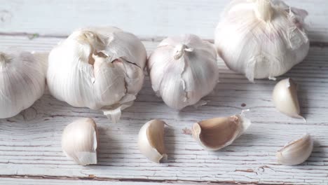 fresh garlic bulbs and cloves on a wooden surface