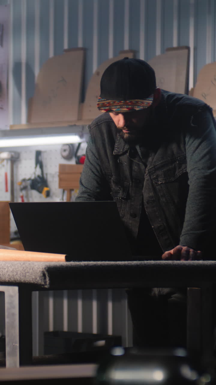 Craftsman Working on a Laptop in a Workshop