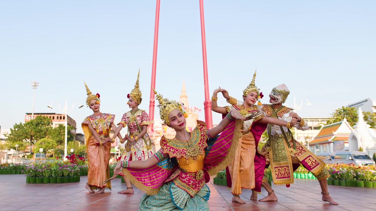 Danzatori in costumi sontuosi eseguono la tradizionale coreografia Khon all'aperto vicino alla storica Altalena Gigante.