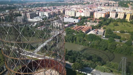 aerial drone forward moving shot over an old iron structure, gasometro or gazometro in ostiense district of rome, italy on a sunny day