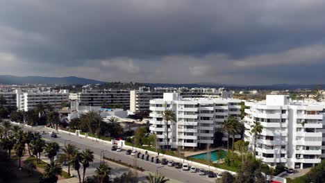 drone rising by some white apartment complexes on ibiza