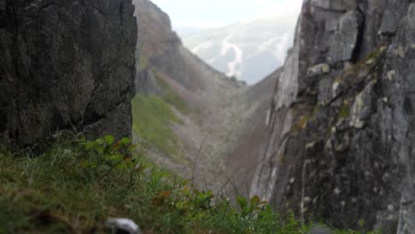 Rise-rack-focus-reveal-shot,-unveiling-rocky,-stony-Dromskåran-valley-with-green-vegetation-scattered-in-Bastudalen-Nature-Reserve,-Jämtland,-Sweden