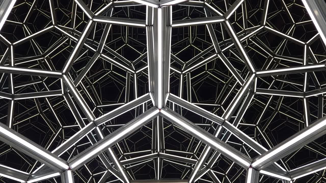 Futuristic mirrored geometric light structure with infinite reflections