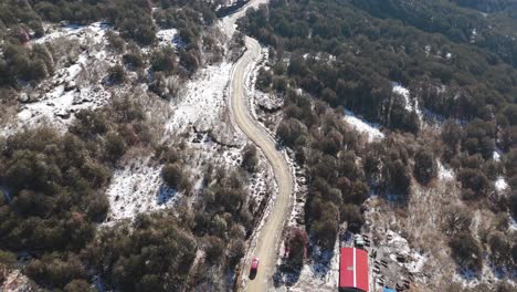 aerial view of a winding mountain road in the snow