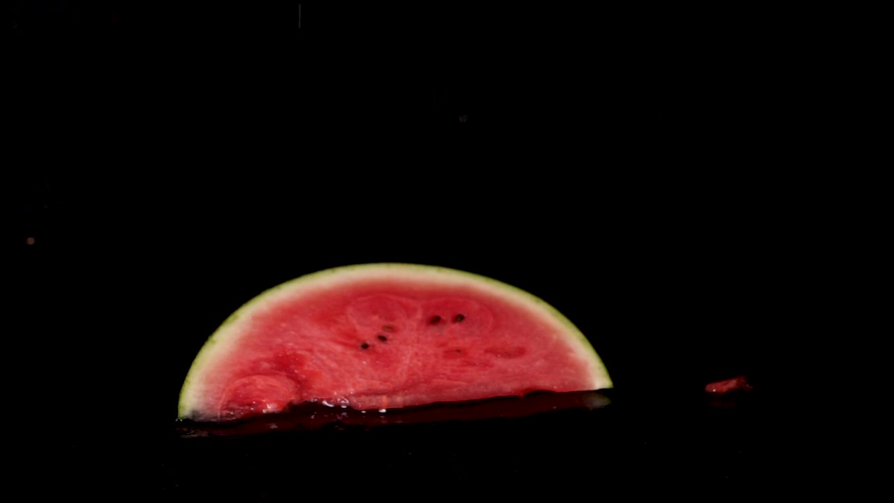 Slow Motion Footage Of Falling Fresh Watermelon Slice Into Water Surface