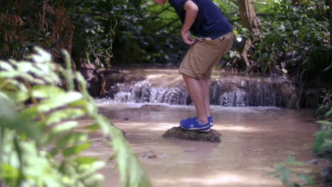 man by a creek in the forest