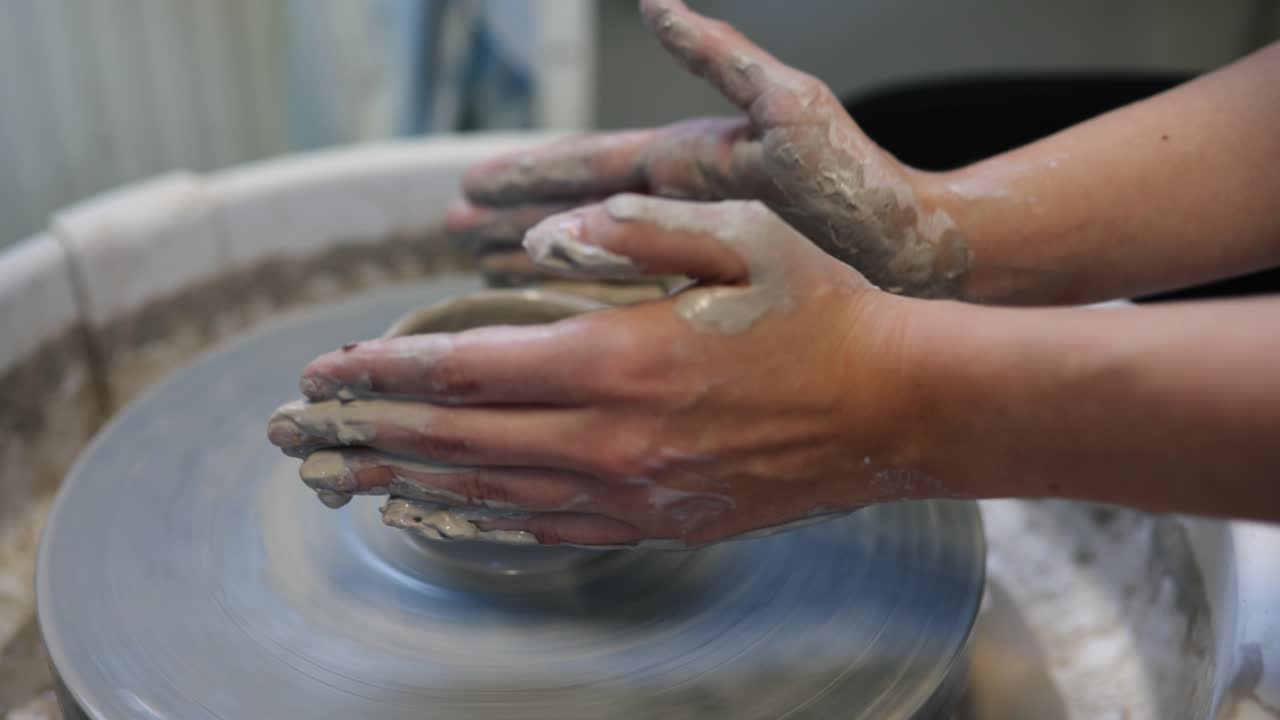 mujer joven artista haciendo cuenco de arcilla en torno de alfarería