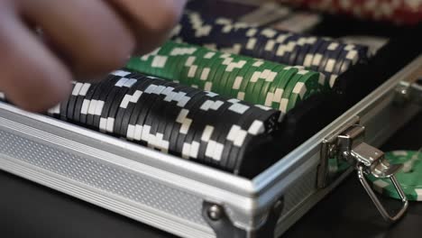 brushing a stack of black casino markers forward in a case