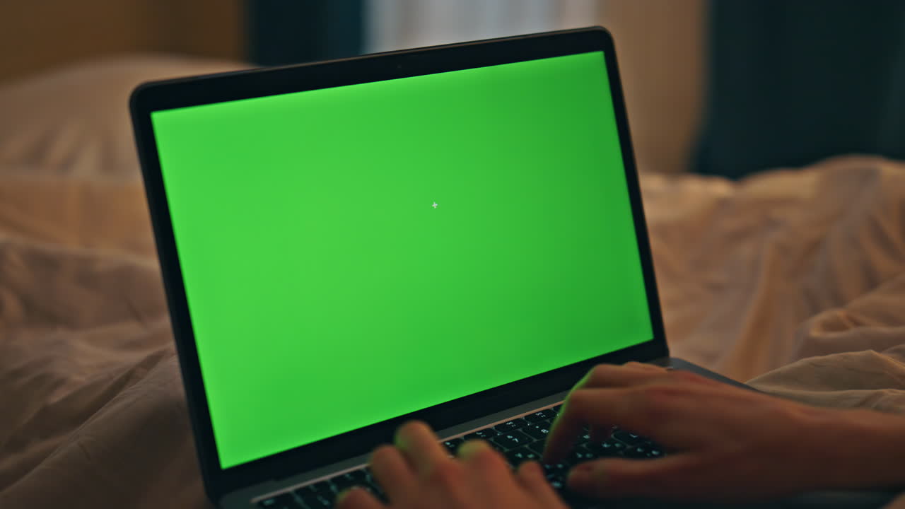 mani che scrivono a casa chromakey laptop di notte closeup. sera persona che naviga sul web