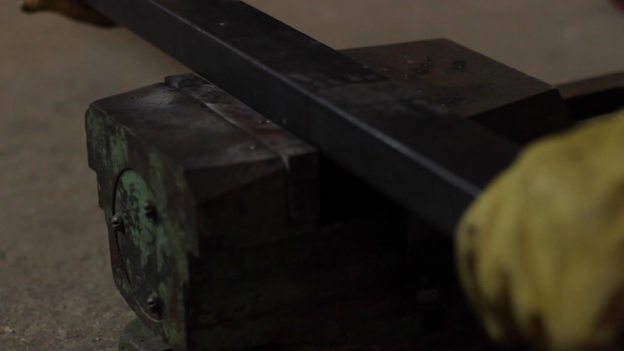 Metal frame pipe being fit in a workbench vise, closeup