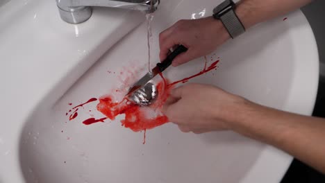 murder knife smeared with blood being washed in a sink in slow motion