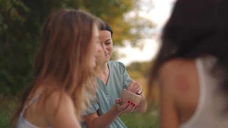 mujeres jóvenes atractivas en áreas abiertas de la naturaleza se dedican a modelar a partir de arcilla dar forma a los productos comunicarse compartir impresiones reír dar consejos recomendaciones entre sí.