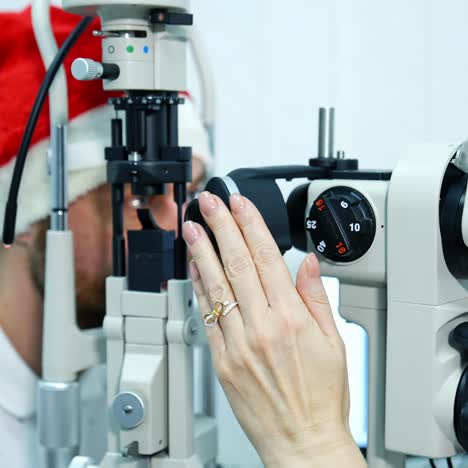 ophthalmologist checks eyesight of young man with modern equipment. doctor is checking eyes with biomicroscope device. doctor examining eye structure with help of medical equipment