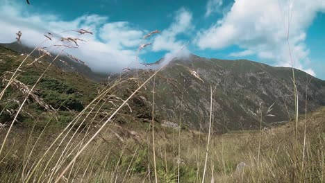 Low-Angle-Slow-Motion-Mountain-View-Mit-Bergrücken,-Weißen-Wolken-Und-Einem-Blauen-Himmel-In-Einem-Tal-In-Den-Fagaras-Karpaten