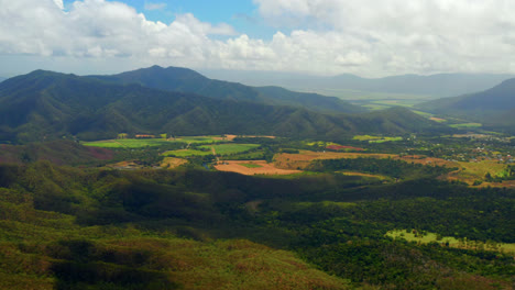 landscape of lush green fields and mountains in atherton tablelands, queensland, australia - aerial drone shot