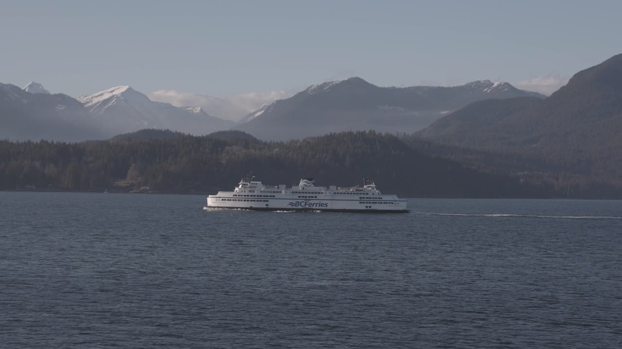 BC ferry boat navigating on sea water with mountains in background, British Columbia. Vancouver in Canada. Aerial drone view