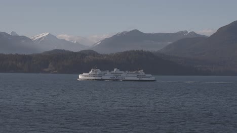bc ferry boat navigating on sea water with mountains in background, british columbia. vancouver in canada. aerial drone view
