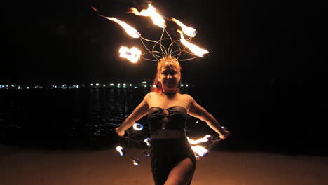 a young woman dancing with her fire ring at night during her show in front of the pier. slowmotion