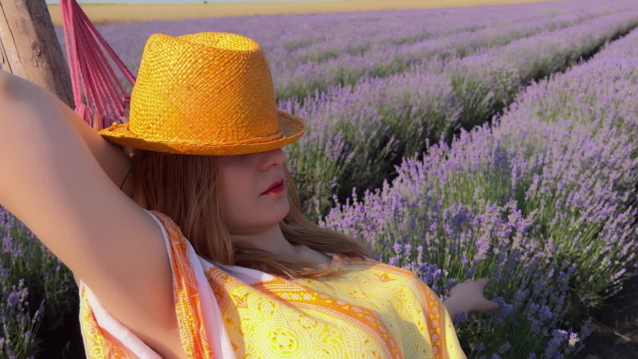 sacar de un campo de lavanda a un primer plano de una mujer joven con sombrero naranja balanceándose en una hamaca