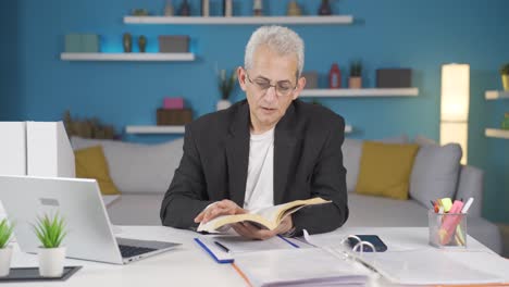 Hombre-Trabajador-De-Oficina-En-Casa-Leyendo-Un-Libro.