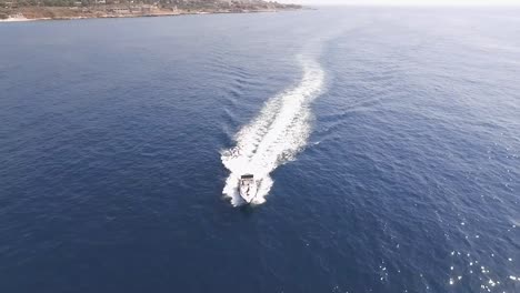 circle aerial pan of luxury white yacht traveling on blue ocean water on sunny day