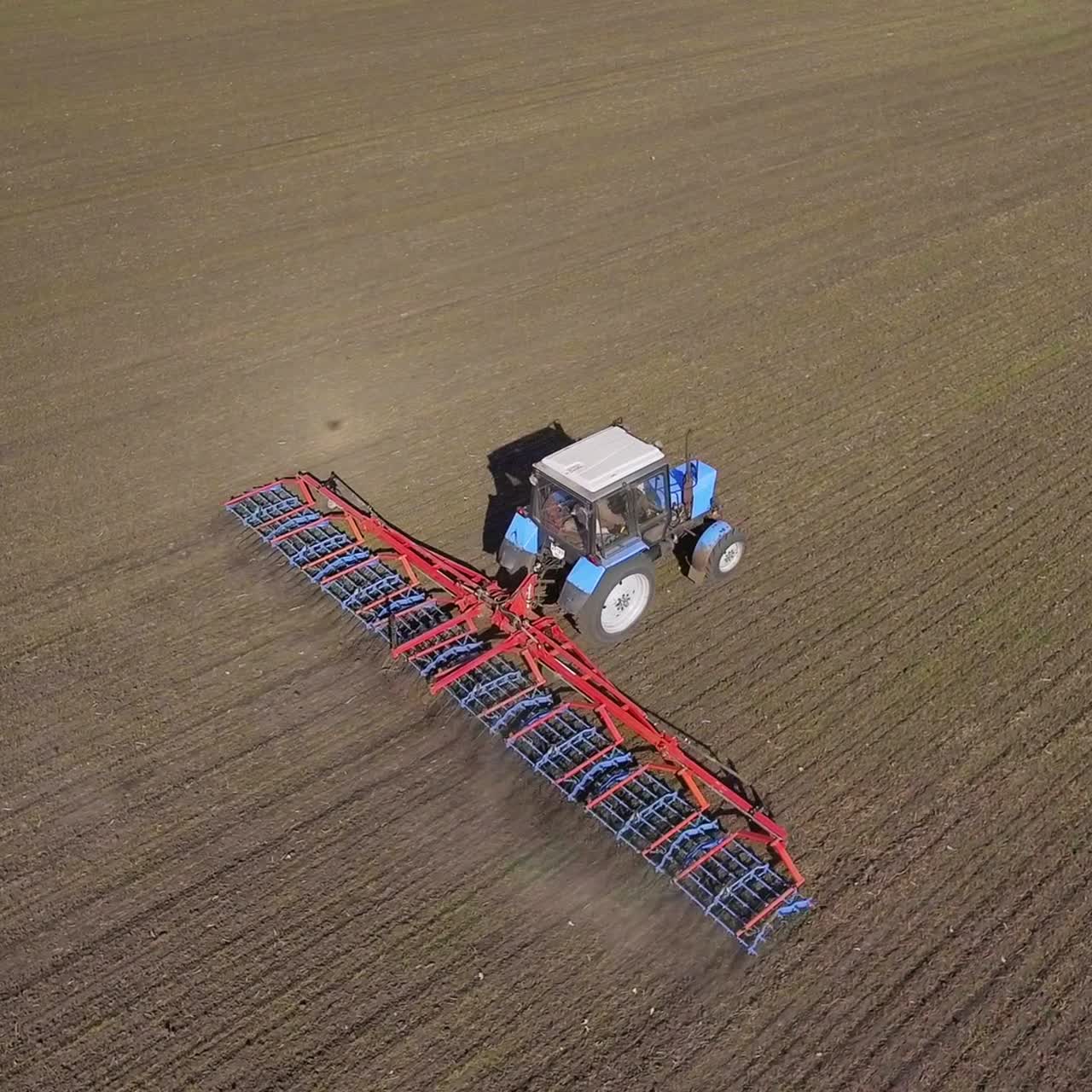 Il trattore traina un attrezzo agricolo per l'erpicatura del terreno 4