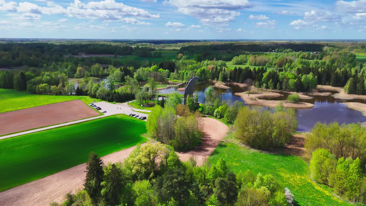 A Stunning View Unfolds From the Kirkilai Observation Tower, Revealing Winding Boardwalks, Serene Karst Lakes, and Lush Forested Surroundings in Biržai Regional Park, Lithuania - Orbit Drone Shot