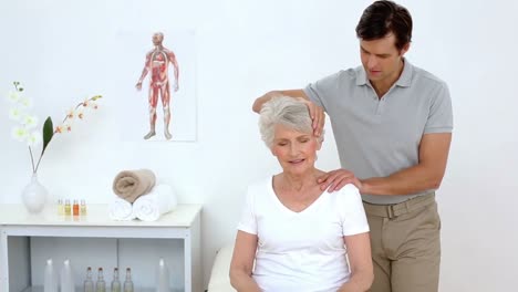 physiotherapist checking senior patients neck