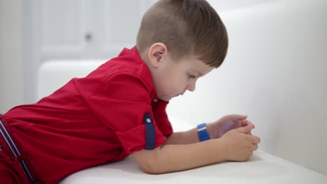 Little-boy-playing-with-his-phone-wearing-glowing-shoes.-Shot-in-4k