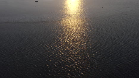 golden sun reflecting on the waters of ria formosa lagoon in algarve, portugal at sunset