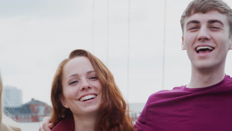 retrato al aire libre de amigos estudiantes de pie en el puente de la ciudad juntos