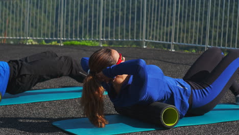 people doing back foam rolling outdoors