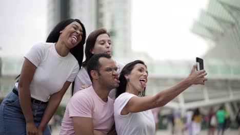 jóvenes sonrientes haciendo expresiones faciales para selfies
