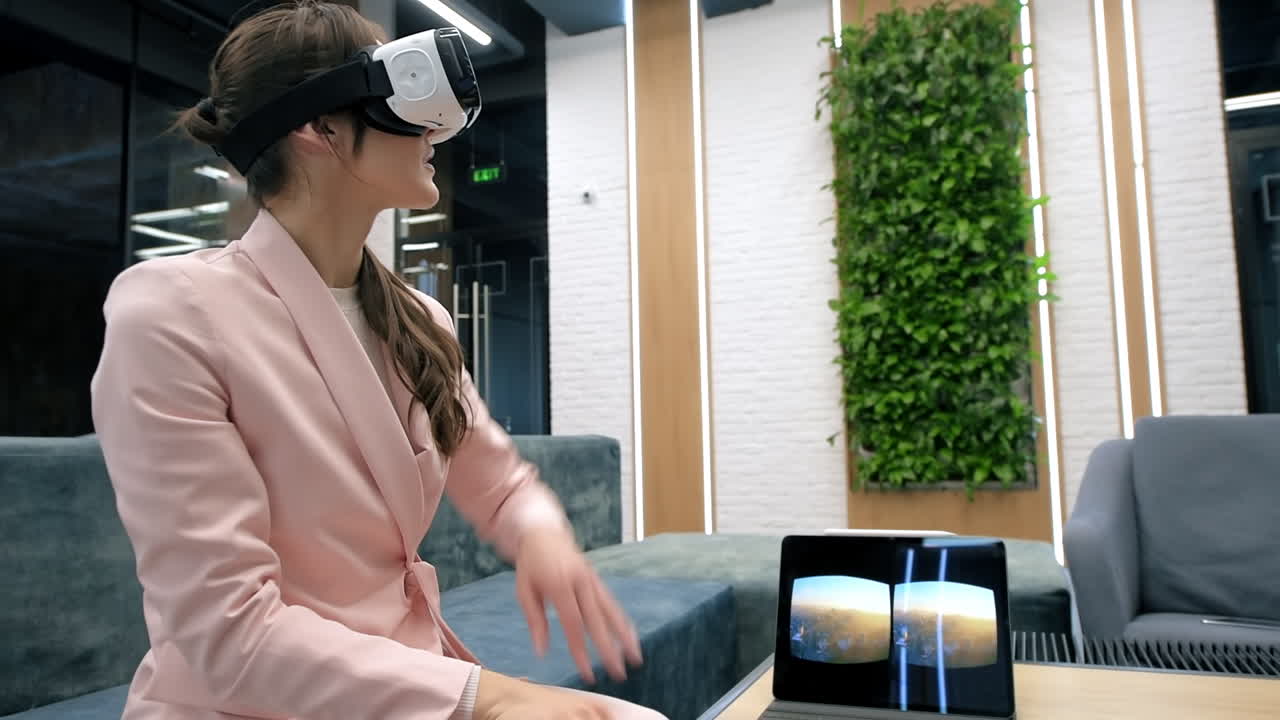Una donna caucasica bionda esplora la realtà virtuale usando occhiali VR in un ufficio. Sul tavolo è presente un tablet che mostra l'immagine visibile nel visore.
