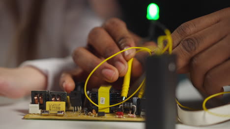 el técnico toca los diodos con sondas que muestran a un pequeño estudiante