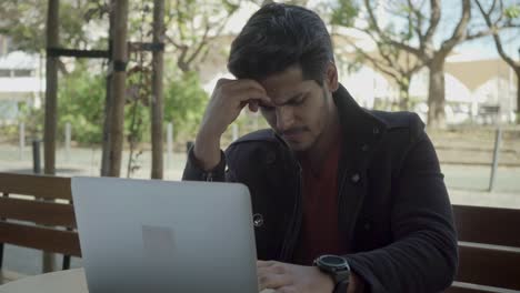 Serious-young-man-thinking-and-working-with-laptop