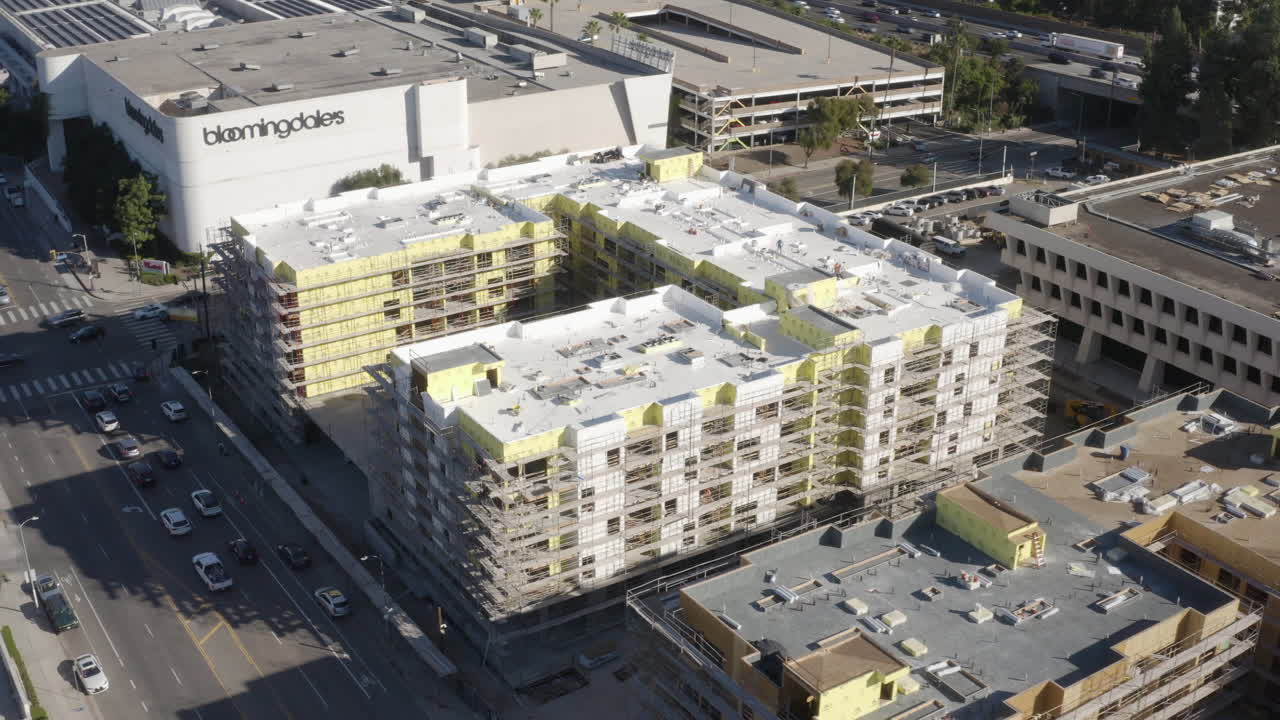 캘리포니아 셔먼 오크스 (sherman oaks) 의 대형 아파트 건설의 4k 드론 촬영, 101 고속도로가 배경입니다.