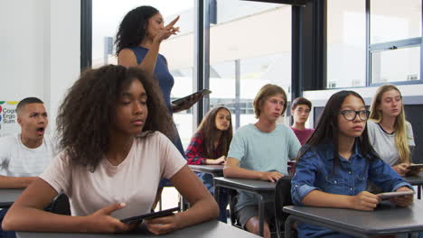 teacher addressing pupils from the back of her high school class