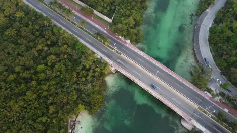 drone shot panning over the punta nizuc bridge in cancun mexico over the nichupte lagoon surrounded by a mangrove forest and emerald green river canal