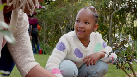 Happy-african-american-grandmother-and-granddaughter-gardening-and-high-fiving,-slow-motion