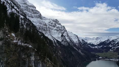 El-Vuelo-Lateral-De-Klöntalersee,-Suiza,-Revela-Grandes-Montañas-Nevadas