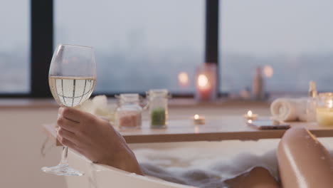 Camera-Focuses-On-A-Woman's-Hand-Holding-A-Glass-Of-Wine