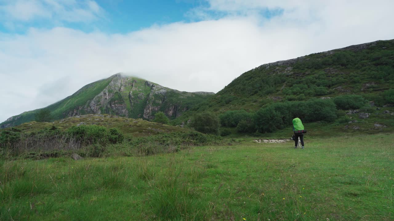 trekking turístico para mochileros con un perro en un sendero de montaña cerca de lurøyfjellet, noruega