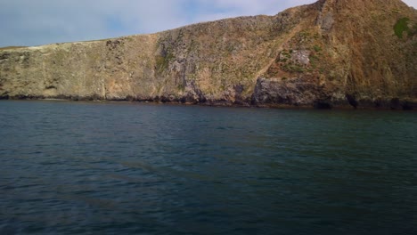 gimbal tilting up shot from a moving boat of the coastline of middle anacapa island at channel islands national park in the pacific ocean