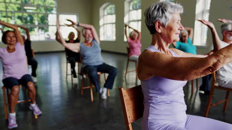 senior citizens engaging in chair yoga class