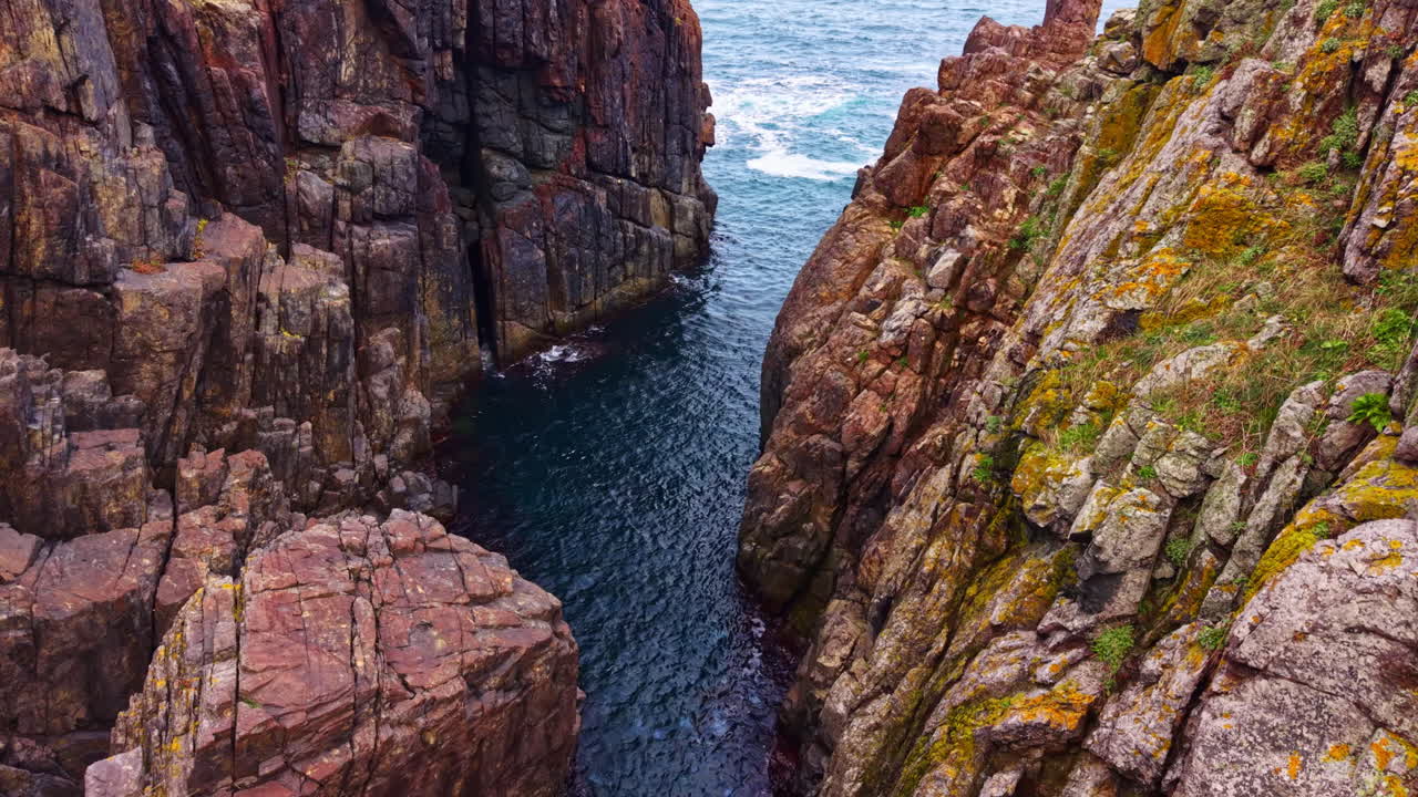 Exploring a rugged coastal canyon with turquoise waters in a serene marine landscape on a bright, sunny day